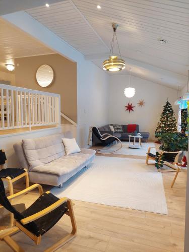 a living room with a couch and a christmas tree at House between pines 5-bedroom house with 3 toilets in Rovaniemi