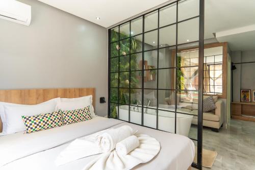 una camera da letto con un grande letto bianco con una parete di vetro di Luxury Balnéo appartement a Marrakech