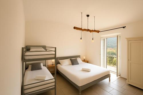 a bedroom with two bunk beds and a window at Apartment Sotto Il Santo in Orco Feglino