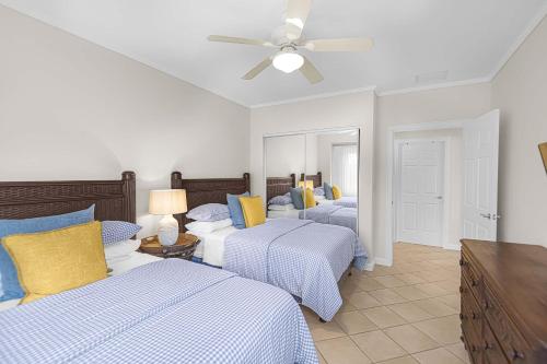 a bedroom with three beds and a ceiling fan at Del Mar 5F 3 bdr Garden View in Los Suenos in Herradura