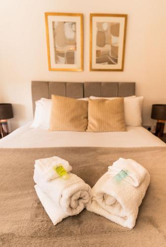 a bedroom with a bed with towels on it at 36 Handley's Elite Apartment 2Bed Flat CityCenter in Hemel Hempstead
