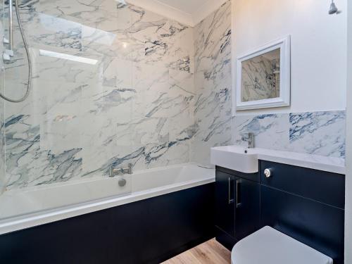 une salle de bain avec une baignoire blanche et un lavabo dans l'établissement 2 Bed in Biggar 95516, à Biggar