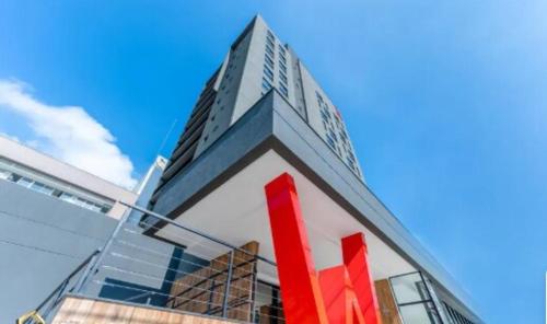 a building with a red sign on the side of it at Loft completo in Blumenau