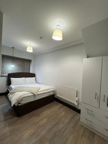 a bedroom with a bed and two lights on the ceiling at En-suite studios near Wembley Stadium in Northwood