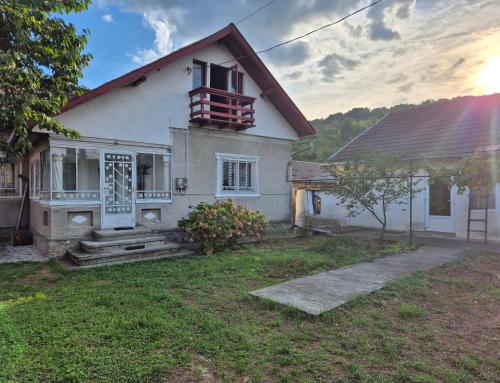 a white house with a window and a balcony at Căsuța de la linie in Moroeni