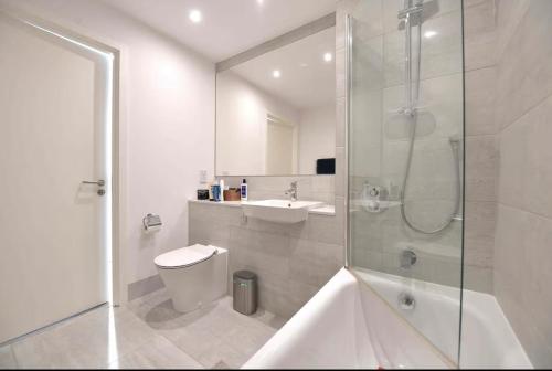 a bathroom with a shower and a toilet and a sink at Modern & charming home in Hackney in London