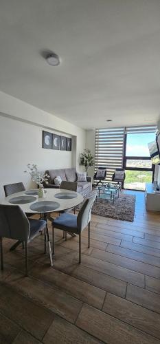 a living room with a couch and tables and chairs at Depa Equipado para 6 - Cerca Fundidora, TEC & Estadio BBVA in Monterrey