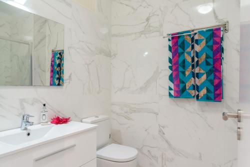 a white bathroom with a toilet and a sink at Vegan Topfloor - Douro e Ribeira in Bandeira