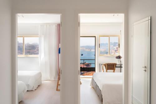 a bedroom with two beds and a view of the ocean at Vegan Topfloor - Douro e Ribeira in Bandeira