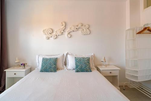 a bedroom with a white bed with blue pillows at Vegan Pátio - Douro e Ribeira in Bandeira