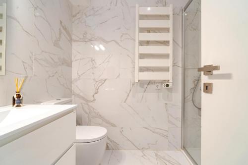 a white bathroom with a toilet and a shower at Vegan Pátio - Douro e Ribeira in Bandeira