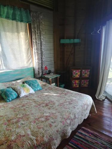a bedroom with a bed with pillows and a window at Runaway Pineapple Lodge in Mangrove Bight
