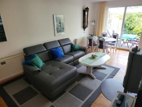 a living room with a leather couch and a table at Ferienhaus Neo in Schillig am Meer in Wangerland