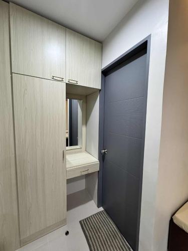 a room with a door and a drawer and a mirror at Davao Persimmon Suites in Davao City
