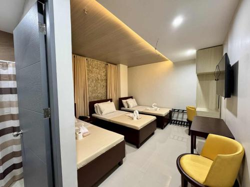 a hotel room with two beds and a television at Davao Persimmon Suites in Davao City