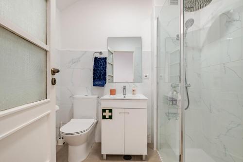 a white bathroom with a toilet and a shower at Vegan Apartment - Porto e Douro in Bandeira