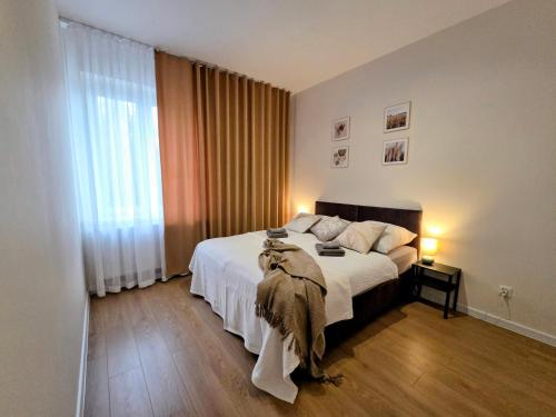 Un dormitorio con una cama y una ventana grande. en Apartament w Starym Koszarowcu, en Borne Sulinowo