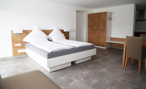 a bedroom with a bed with white pillows on it at Ferienwohnungen Joachim Fischer in Vaihingen an der Enz