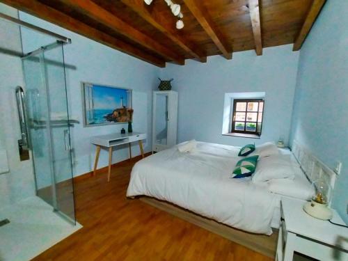 a bedroom with a bed and a glass shower at Urdaibai alojamientos en reserva de la biosfera in Isla Becoa