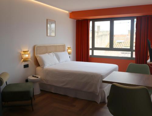 a hotel room with a bed and a window at Aparthotel Casa Fages in Figueres