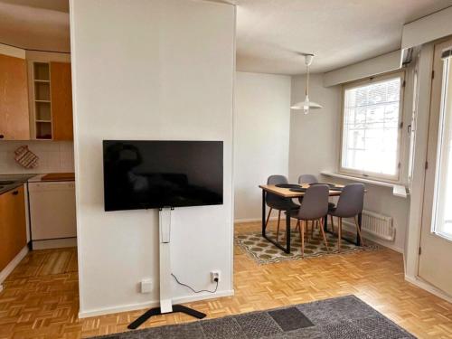 Una sala de estar con una mesa y un televisor en una pared. en Peaceful Apartment with Sauna and Nature Views, en Sodankylä