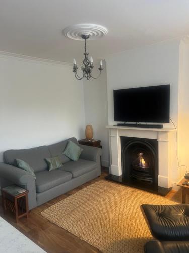 a living room with a couch and a fireplace at Luxury apartment with 2-Beds in Beckenham