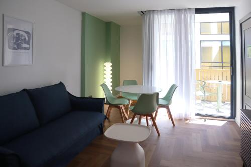 a living room with a couch and a table and chairs at Aparthotel Casa Fages in Figueres