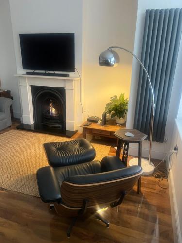 a living room with a chair and a fireplace at Luxury apartment with 2-Beds in Beckenham