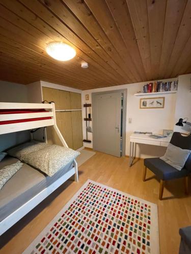 a bedroom with a bunk bed and a chair at Kiwi Ferienwohnung in Bludenz