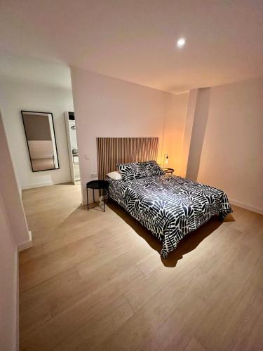 ein Schlafzimmer mit einem Bett und einem Holzboden in der Unterkunft Encantador Apartamento Familiar in La Cuesta