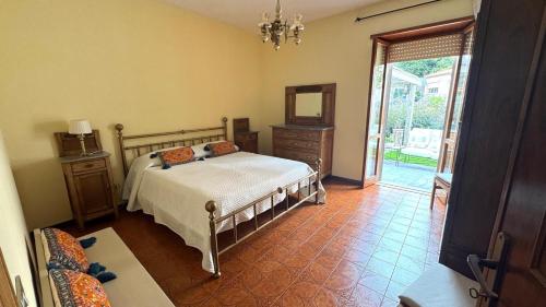 a bedroom with a bed and a dresser and a window at La Via delle Rose in Tempio Pausania