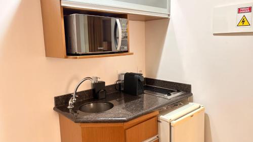 a kitchen with a sink and a microwave at Studio Completo - Vila Olímpia - Moema in São Paulo