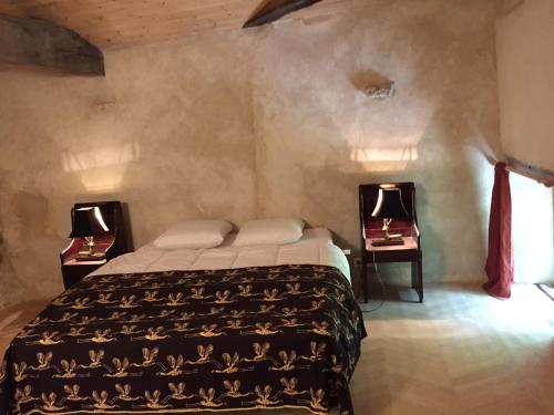 a bedroom with a bed with two lamps on two tables at DameChouette in Pujols