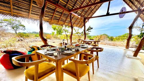 a dining room with a table and chairs on a patio at Enchanted Escapes Yala in Kirinda