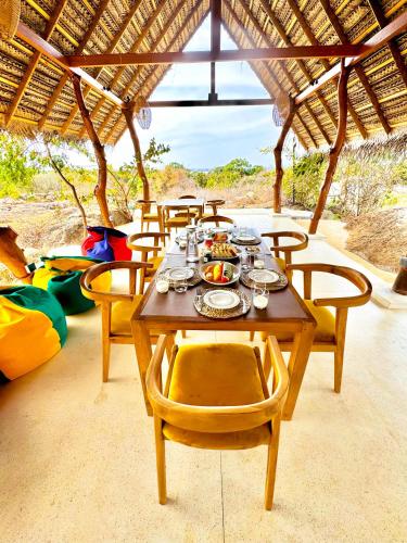 Una mesa de madera con platos de comida encima. en Enchanted Escapes Yala, en Kirinda