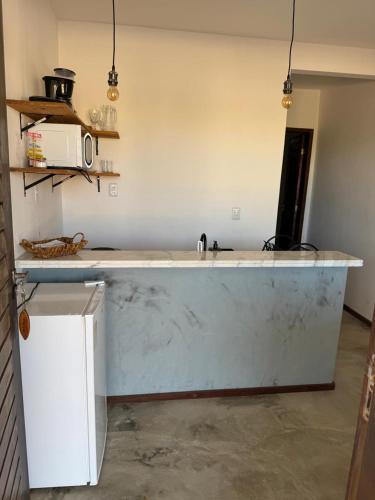 a kitchen with a white counter top in a room at Apartamentos Ventos da Sibauma in Tibau do Sul