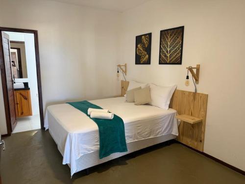 a bedroom with a bed with two towels on it at Apartamentos Ventos da Sibauma in Tibau do Sul