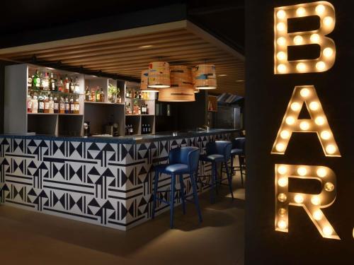 a bar with blue chairs and a b sign at Ibis Styles Abidjan Plateau in Abidjan