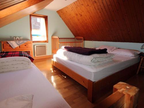 a bedroom with two beds in a attic at Appartement cosy au cœur de Vagney, proche commerces et sentiers, terrasse et cheminée, à 15km Gérardmer - FR-1-589-304 in Vagney