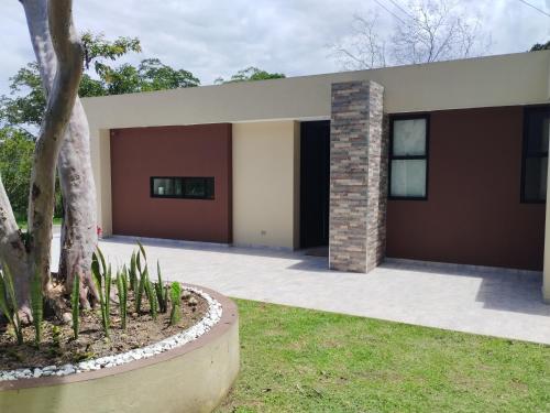 a house with a tree in front of it at Avemaría! in Puente Nacional