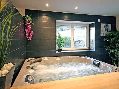 a large bath tub in a room with a window at Ferme Vosgienne rénovée avec spa, sauna, jacuzzi, billard et étang privé en pleine nature - FR-1-589-327 in Saulxures-sur-Moselotte