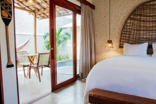 a bedroom with a bed and a balcony at Pousada Vilagoa in Coqueiro Sêco