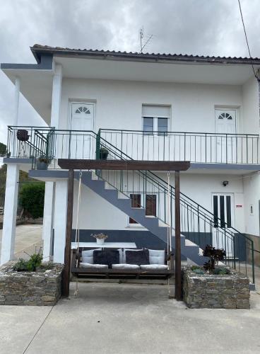 a white house with a staircase in front of it at Alojamento D. Duarte in São Paio