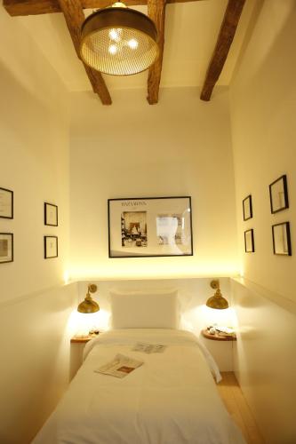 a bedroom with a bed with two lights on it at Bazaar Inn Hotel in Tirana