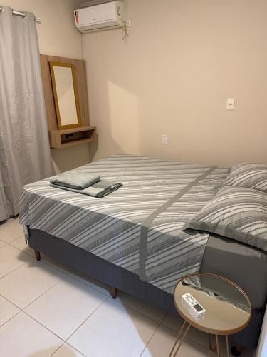 a bedroom with a bed and a chair and a mirror at Apartamento Novo no Centro de Pomerode in Pomerode
