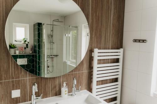 a bathroom with a sink and a mirror at Vakantiehuisje met ruime tuin en hottub in Ouddorp