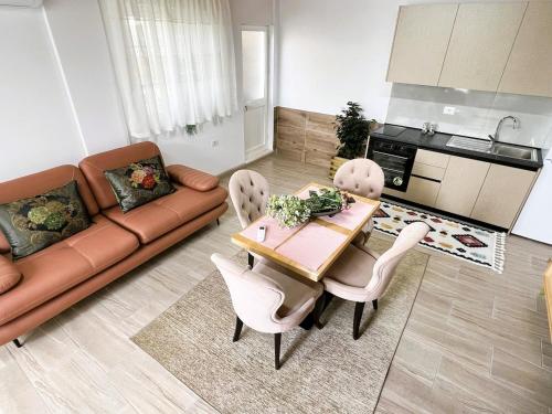 a living room with a couch and a table and chairs at Vila Hysaj in Kamëz