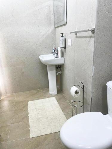 a bathroom with a white sink and a toilet at Vila Hysaj in Kamëz