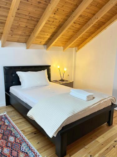 a bedroom with a large bed with a wooden ceiling at Vila Hysaj in Kamëz
