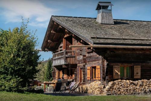 an old log cabin with a balcony and a chimney at Chalet Patagonia - OVO Network in La Clusaz
